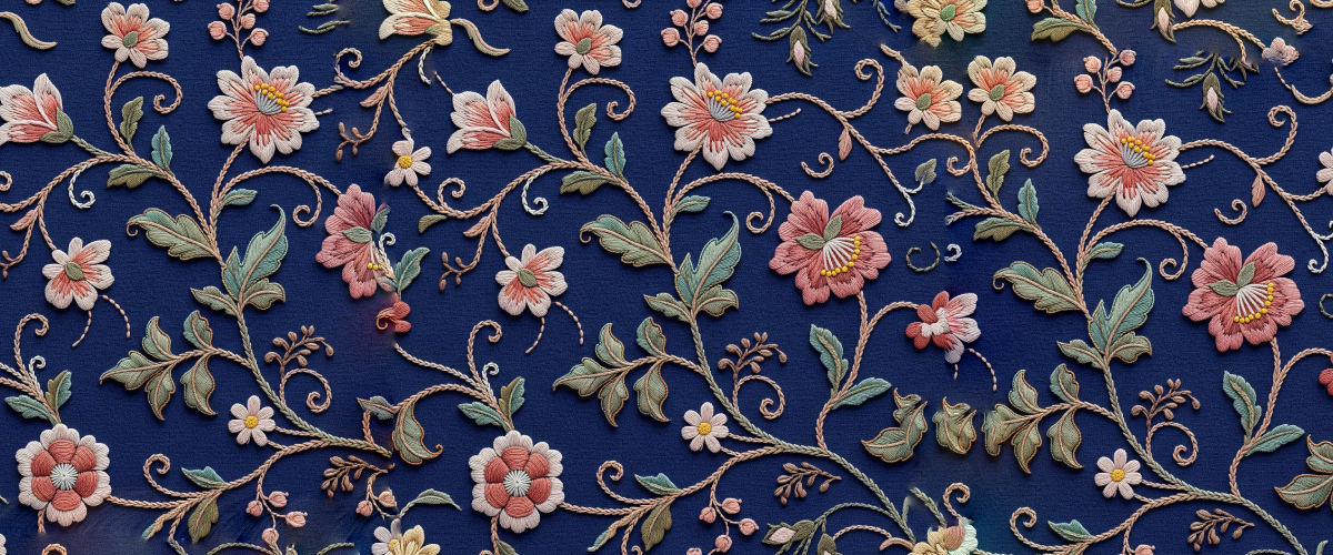 A detailed floral embroidery Photoshop pattern with pink and white flowers on a dark blue fabric background freebie